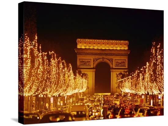 a night view of the arc de triomphe and the champs elysees lit up